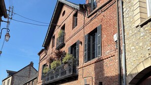 A brick building with a balcony, a garage door, and a stone facade.