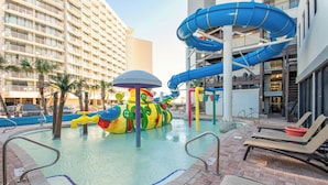 Een waterpark met glijbanen, een zwembad en ligbedden.