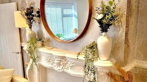 A living room with a white fireplace, a round mirror above it, and a sofa. - Manchester - City Centre - Hot Tub - Free Private Parking - Sleeps 8 (Greater Manchester)