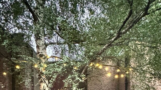 A hot tub in a backyard with brick walls, string lights, and outdoor furniture. - Manchester - City Centre - Hot Tub - Free Private Parking - Sleeps 8 (Greater Manchester)