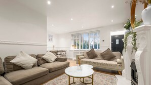 A living room with two sofas, a round coffee table, and a fireplace. - Manchester - City Centre - Hot Tub - Free Private Parking - Sleeps 8 (Greater Manchester)