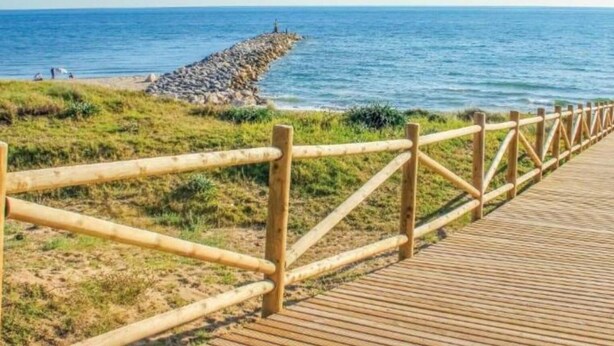 A wooden boardwalk leading to a rocky shoreline with a view of the sea. - Marbella Oasis Villa With 6 Bedrooms (Marbella)