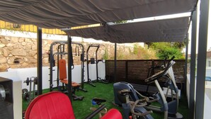 An outdoor gym with various exercise equipment, including a bench press, a squat rack, and an elliptical machine. - Marbella Oasis Villa With 6 Bedrooms (Marbella)