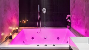 A modern bathroom with a large bathtub, a glass shower enclosure, and a wooden vanity. - MAIN - Duomo (Naples)