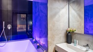 A modern bathroom with a glass-enclosed shower, a white sink, and a large mirror. - MAIN - Duomo (Naples)