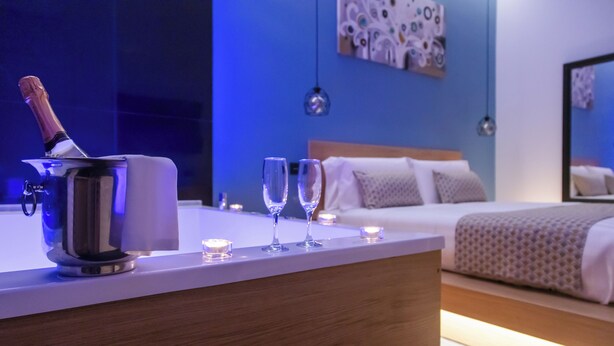 A modern hotel room with a minibar, two glasses, and a bottle of champagne. - MAIN - Duomo (Naples)