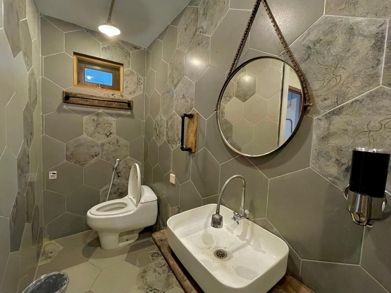 A bathroom with a toilet, sink, and a mirror.