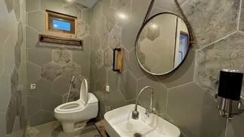A bathroom with a toilet, sink, and a mirror.