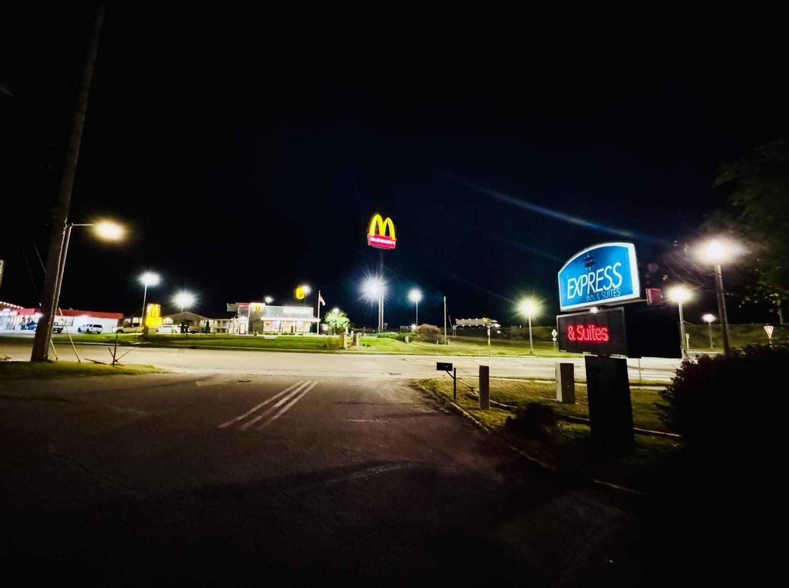 A McDonald's and Express Inn & Suites sign at night.