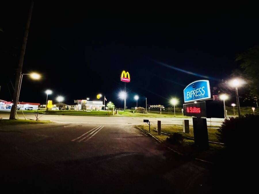 A McDonald's and Express Inn & Suites sign at night.