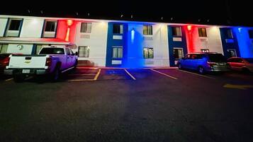 Un motel con un estacionamiento y varios automóviles estacionados.