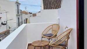 A small outdoor balcony with two wicker chairs and a round wooden table. - Zinnia Villa, Tavira, Algarve (Tavira)