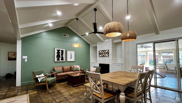 A spacious living area with a dining table, sofas, and a fireplace. - Big Heated Pool w Sunroom, Centrally-loc. Luxury in Houston, Billiards, Sleeps16 (Houston)