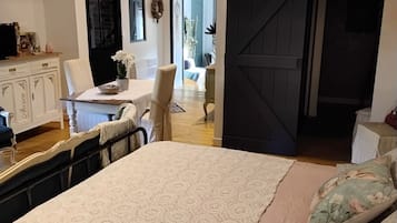 Une chambre avec un grand lit, un plafond en bois, un bureau avec une chaise et une armoire.