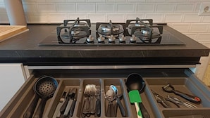 A kitchen with a black countertop and a drawer containing various utensils. - Your window overlooking St. Peter's (Roma)