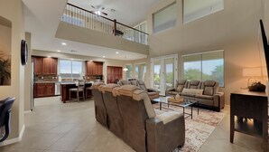 A spacious living area with a high ceiling, a balcony, and a kitchen area. - Cline Maricopa (Maricopa)
