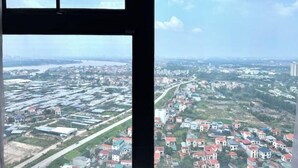 A view through a window of a cityscape with industrial buildings and residential areas.