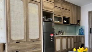 A modern kitchen with wooden cabinets, a stainless steel refrigerator, and a water dispenser.