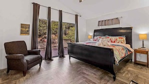 A bedroom with a bed, a chair, a nightstand, and a ceiling fan. - Fanning Flagstaff (Flagstaff)