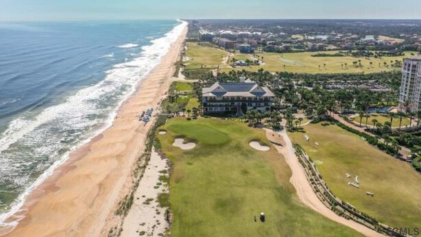 Un bien immobilier situé sur la côte, comprenant un terrain de golf, un accès à la plage et des immeubles résidentiels.