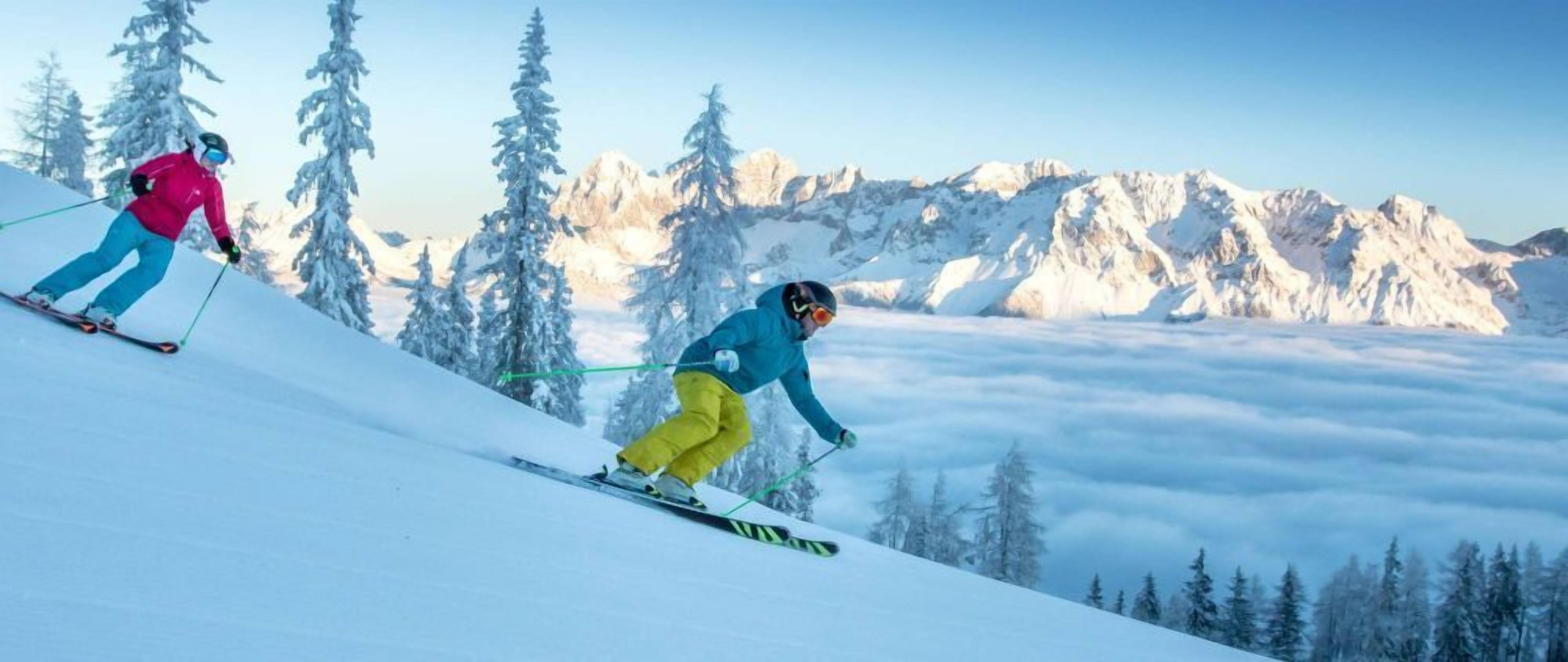 A snowy mountain landscape with skiers.