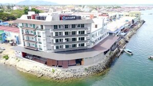Un hôtel à plusieurs étages, doté d’une façade incurvée, situé à proximité du bord de l’eau.