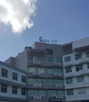 A multi-story building with balconies and a sign that reads 'Café & Bar'. - Pacific Inn (Semporna)
