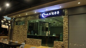 Un Pacific Inn con un diseño moderno, que presenta fachada de piedra y un amplio ventanal.