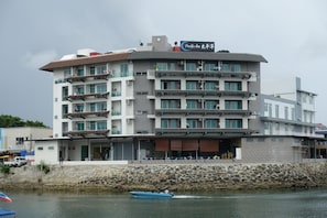 A multi-story hotel with a flat roof, balconies, and a sign indicating it is a Pacific Inn. - Pacific Inn (Semporna)