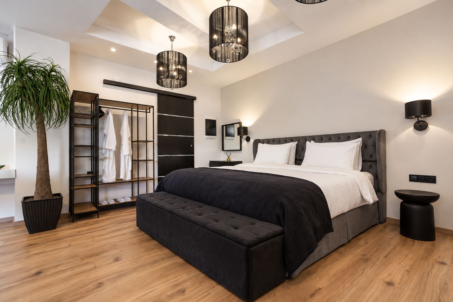 Un dormitorio moderno con una cama grande, un armario empotrado, una planta en maceta y una lámpara de techo.