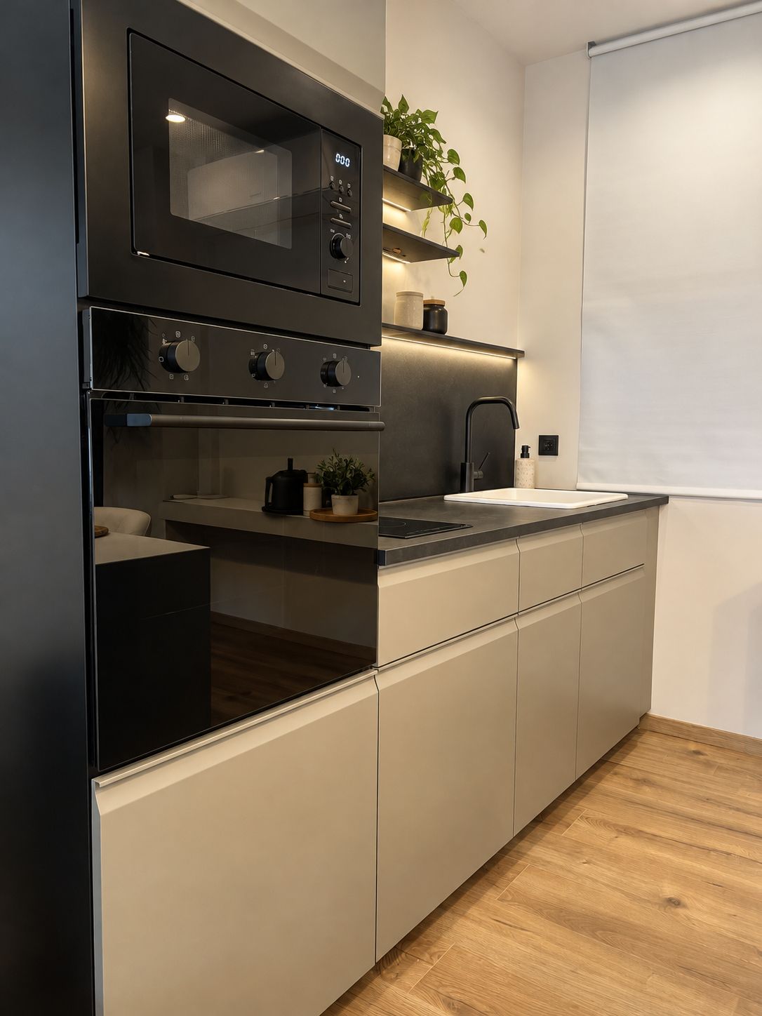 Una cocina moderna con horno empotrado, microondas y lavabo.