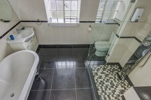 Luxe tweepersoonskamer | Badkamer | Een douche, een haardroger, handdoeken, zeep