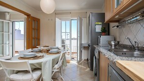 A modern kitchen with a dining area, a refrigerator, a microwave, and a sink.