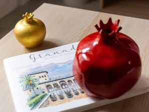 Un folleto con una granada y un adorno dorado sobre una superficie de madera.