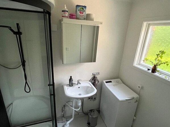 A compact bathroom with a shower, sink, and toilet. - 5 Star Holiday Home in Mollosund (Mollösund)