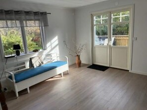 A room with a bed, a window with curtains, a potted plant, and a sliding glass door leading outside. - 5 Star Holiday Home in Mollosund (Mollösund)