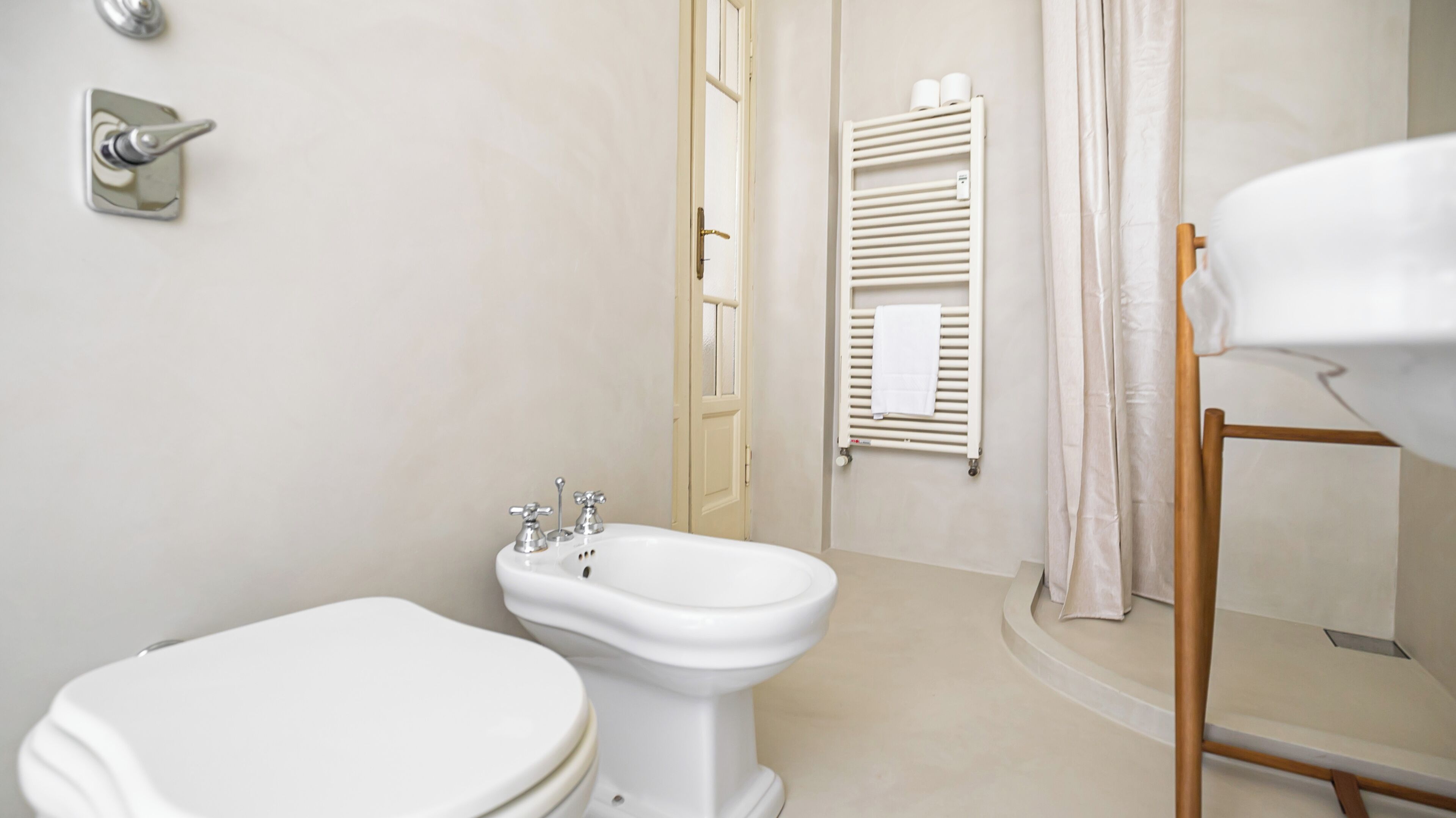 Une salle de bain équipée de toilettes, d’un bidet et d’un porte-serviettes.