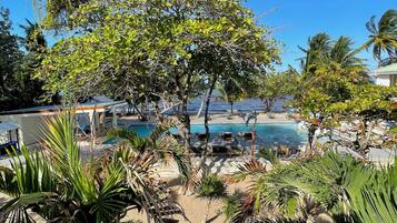 Een buitenzwembad, parasols bij het zwembad en ligstoelen