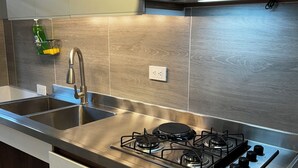A modern kitchen with stainless steel appliances, a double sink, and a microwave above the stove. - Beautiful 2-bedroom apartment in Medellín with Free WiFi, AC- Near El Poblado (Medellín)