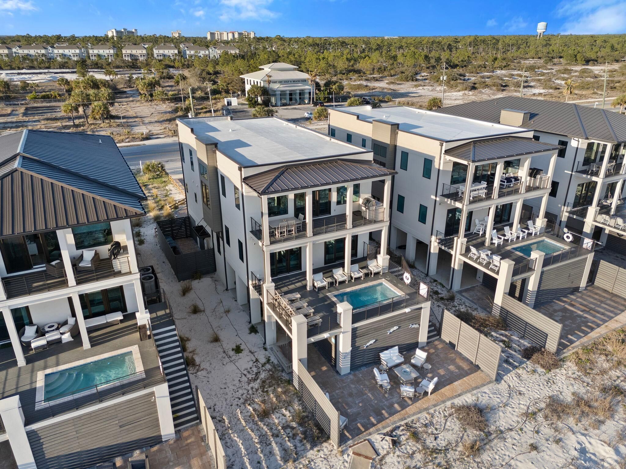 A modern multi-story residential building with a rooftop pool and outdoor seating areas.