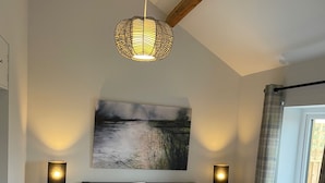 A bedroom with a bed, two bedside lamps, a wall-mounted painting, a window with curtains, and a wooden ceiling beam. - Moments From Beach/lodge/naturereserve/ Sandilands (Mablethorpe)