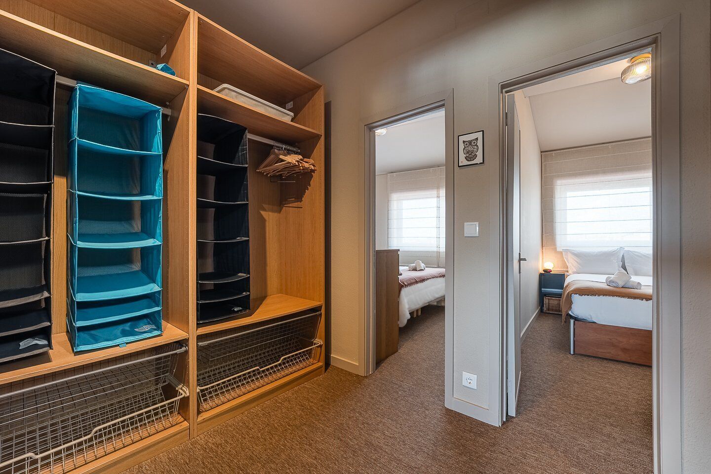 Hotelkamer met inloopkast, een bed met nachtkastje en een raam met jaloezieën.