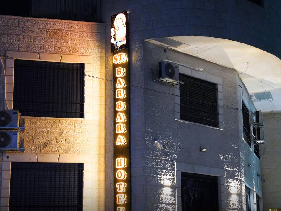 Un edificio con un letrero de neón que dice 'St. Barbara Hotel'.