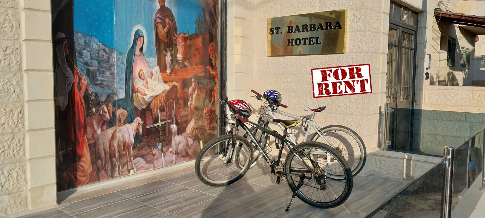 A bicycle parked in front of St. Barbara Hotel with a 'For Rent' sign.