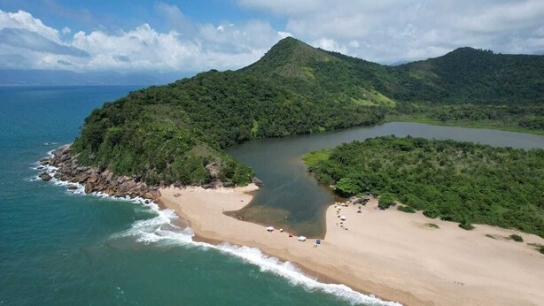 Un paysage côtier comprenant une plage, un lac et une montagne.