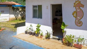 Un bâtiment à deux étages doté d’un balcon, de plantes en pot et d’une bouée de sauvetage fixée au mur extérieur.