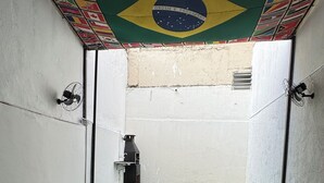 Una habitación con alfombra verde, paredes blancas y un techo decorado con diversas banderas nacionales.