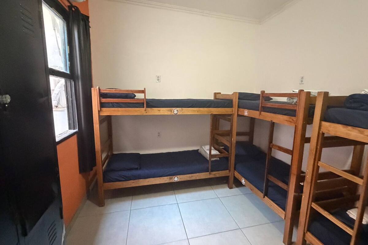 A room with bunk beds, a window, and a door.