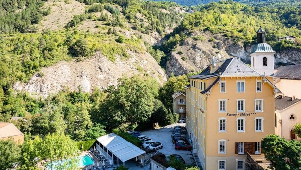 A hotel with a swimming pool, surrounded by lush greenery and hills. - Wifi, resort center, fitness, balcony, tv, 25-32m², Brides Les Bains (Brides-les-Bains)