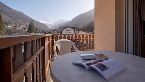 A balcony with a table and chair, overlooking a mountain landscape and a hotel sign. - Wifi, 200m from ski lifts, fitness, balcony, tv, 31m², Brides Les Bains (Brides-les-Bains)